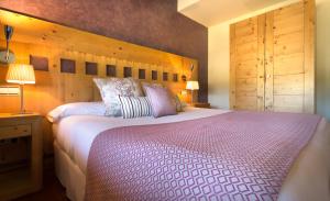 埃尔巴科-德阿维拉依赞格雷多斯门酒店的一间卧室设有一张大床和木墙