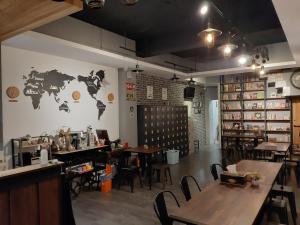 台南清淨背包客棧-民權館Quiet Hostel - Minquan Inn的墙上有桌子和世界地图的餐厅