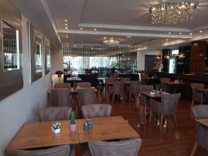 因戈尔施塔特Hotel Starton am Village的一间带木桌椅的餐厅和一间酒吧