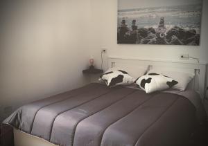 塔兰托Satyria Apartments的一间卧室配有一张带黑白枕头的床