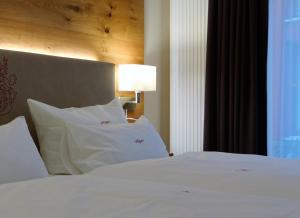 巴特埃森胡歌餐厅酒店的一间卧室配有带白色床单和枕头的床。