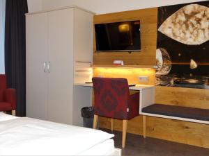 巴特埃森胡歌餐厅酒店的客房设有书桌、椅子和床。