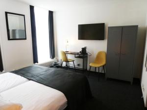 多克姆波斯特霍恩餐厅酒店的酒店客房配有一张床、一张书桌和一台电视。