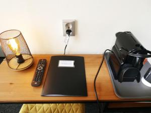 多克姆波斯特霍恩餐厅酒店的一张带笔记本电脑、电话和台灯的书桌