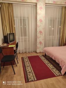 哈尔科夫亚历山大酒店的一间卧室配有一张床、一张桌子和一台电脑