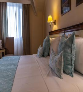 埃尔卡拉法特奥拓卡莱发特酒店的卧室配有带枕头的床铺和窗户。