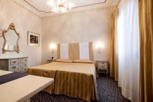 威尼斯普林西皮酒店的酒店客房,设有两张床和镜子