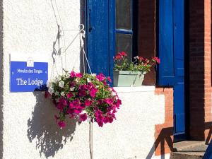 Moutier-MalcardMoulin des Forges Gites, Camping et Glamping的窗前有鲜花的门上的标志