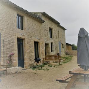 ÉchiréChâteau des Loups - Les Cèdres Bleus的砖砌的建筑,设有烧烤架和野餐桌