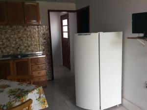 里奥格兰德Pousada do Mar的厨房配有白色冰箱,设有桌子