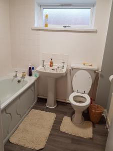 考文垂Wonderland Guest House的浴室配有卫生间、盥洗盆和浴缸。