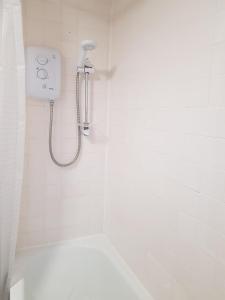 考文垂Wonderland Guest House的白色的浴室设有淋浴,墙上配有电话