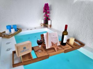 米科利维亚Coralli Beach Apartments的托盘,内含一瓶葡萄酒和一杯葡萄酒