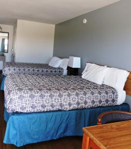 马尔法Riata Inn - Marfa的酒店客房配有一张床铺和一张桌子。