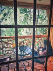圣特雷莎盖丘亚生态山林小屋的坐在门廊上喝杯咖啡的女人
