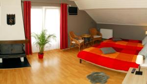 迪南奥博盖尔勒弗瑞酒店的一间卧室配有红色和橙色的床和一张桌子