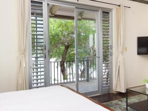 科罗萨尔Almond Tree Hotel Resort的一间卧室设有一张床和一个滑动玻璃门