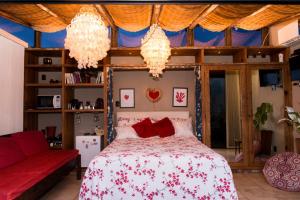 里约热内卢Mansion Aline的一间卧室配有一张带红色枕头和吊灯的床。
