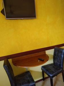 博卡斯德尔托罗The Lighthouse at Casa Max的黄墙旁边的一张桌子和一把椅子