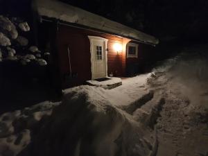 萨伦Backamgården的雪中白门的房子