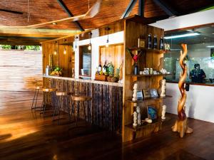 博卡斯德尔托罗La Loma Jungle Lodge and Chocolate Farm的一间设有木墙、木地板和木凳的酒吧