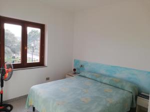 圣特奥多罗Residence Li Menduli的一间卧室设有蓝色的床和窗户。