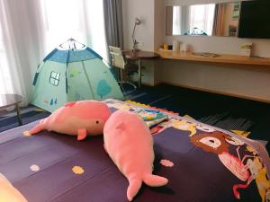 黄岛青岛西海岸智选假日的卧室配有一张床,地板上放着猪