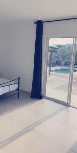 威廉斯塔德Apartment Curacao的一间设有滑动玻璃门并享有游泳池景致的客房