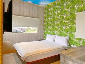 Chongde崇霖覓境-花蓮崇德瑩農場的一间卧室配有一张带绿色墙壁的床