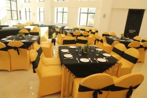 库尔卢City Choice Inn的宴会厅配有桌子和黄色椅子