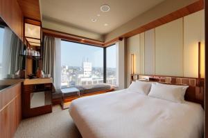 和歌山Candeo Hotels Nankai Wakayama的酒店客房设有一张床和一个大窗户