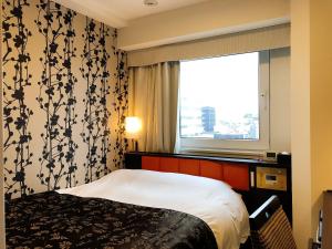 东京APA Hotel Ueno Hirokoji的酒店客房设有床和窗户。