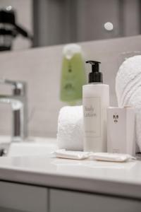 奥伯古格尔Skihotel Haus Gurgl的浴室柜台配有1瓶肥皂和毛巾
