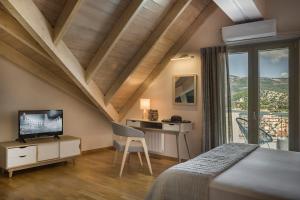 阿尔戈斯托利翁Grand View Maisonette的一间卧室配有一张床、一张书桌和一台电视