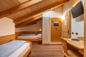 泰塞罗玛索圣利博拉农庄酒店的一间卧室配有两张床、一张桌子和一台电视。