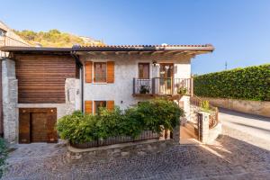 特雷莫西内Borgo Cantagallo Casa Olivia 2的一座带木门和阳台的房子