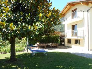 佩尔吉内瓦尔苏加纳Appartamenti Casa Viviana的房子旁边的院子里的一个蓝色长椅