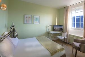 里尔布鲁格勒酒店的一间卧室配有一张床、一张书桌和一台电视