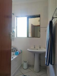 圣卢西亚The Dunes的浴室配有盥洗盆、镜子和浴缸