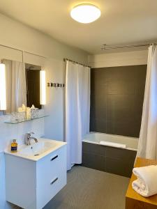 桑利斯美妙旅馆的浴室配有白色水槽和浴缸。