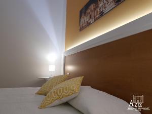 巴勒莫Aziz b&b的卧室内的一张带黄色和白色枕头的床