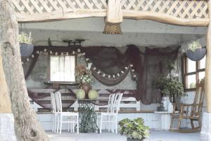 Itziar阿里奥拉塔希奇乡村民宿的凉亭配有白色的椅子、桌子和窗户