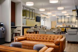 基洛纳Microtel Inn & Suites by Wyndham Kelowna的带沙发的客厅和用餐室