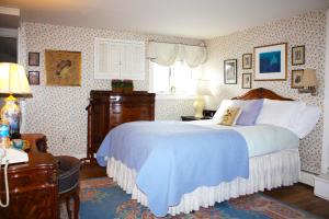 库珀斯敦白屋住宿加早餐旅馆的一间卧室配有一张带蓝色毯子的大床
