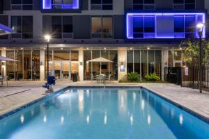 奥兰多TRYP by Wyndham Orlando的一座游泳池,在晚上在建筑物前
