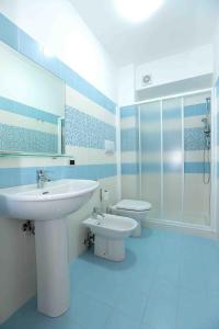卡普多兰多Il Gabbiano - Case Vacanze的蓝色和白色的浴室设有水槽和卫生间
