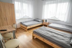 JedliczeDwa Karpie Jedlicze的一间卧室配有两张床、一张桌子和一把椅子