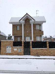 马德里Chalé Barajas Escala的雪中带围栏的房子