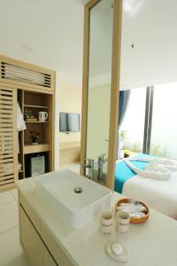 隆海Oceanami Resort的白色的浴室设有水槽和一张床