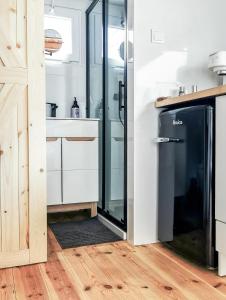 ReguliceLushHills - Tiny House - Modern House On Wheels的厨房配有玻璃淋浴间和冰箱